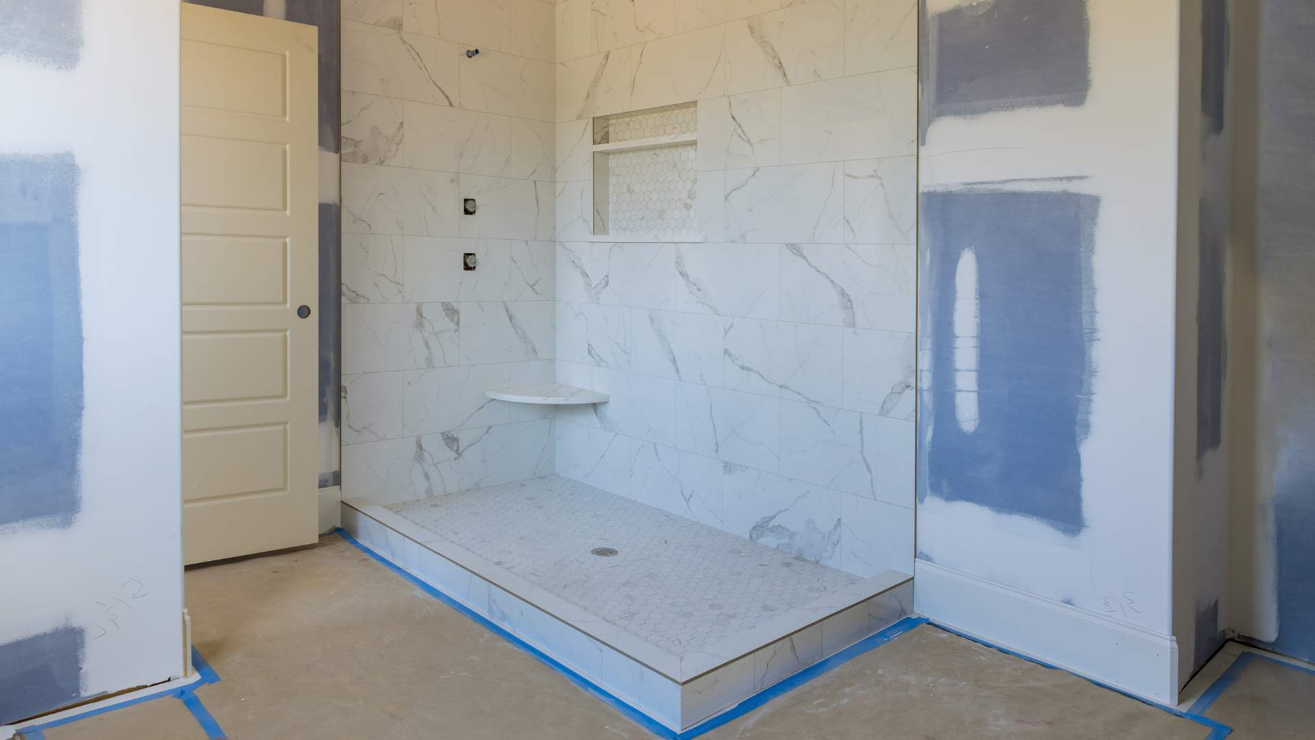 Bathroom remodeling contractor installing tiling bathroom wall